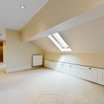 Spacious attic room with skylight and storage.
