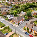 Aerial view of suburban houses and greenery.