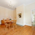 Spacious dining room with wooden floor and table.