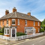 Brick house with white fence on a corner