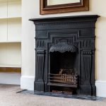 Decorative black fireplace with detailed carvings.