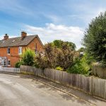 Charming red brick suburban house with garden view.