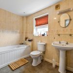 Traditional bathroom with bathtub, sink, and toilet.