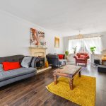 Modern living room with sofas and wooden floor.