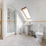 Attic bathroom with shower and skylight.
