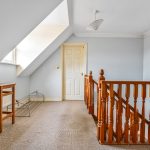 Attic landing with wooden railing and furniture