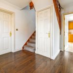 Hallway with wooden floor and stairs leading up.