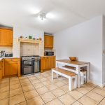 Spacious kitchen with wooden cabinets and tile floor.