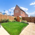 Back garden with grass and fence.