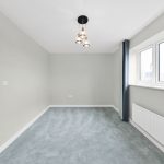 Empty room with light grey walls and carpet
