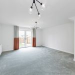 Spacious living room with modern lighting and windows.