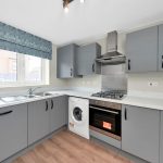 Modern kitchen with grey cabinets and appliances.