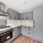 Modern grey kitchen with stainless steel appliances.