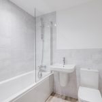 Modern bathroom with bathtub, sink, and toilet