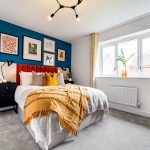 Modern bedroom with colourful decor and gallery wall.