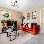 Modern living room with orange sofa and wall art.