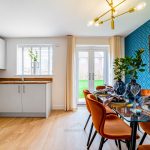 Modern dining area with orange chairs and blue accents.