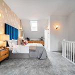 Modern bedroom with blue headboard and skylight.