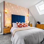 Modern attic bedroom with stylish decor and skylight.