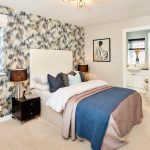 Stylish bedroom with feature wallpaper and soft furnishings.