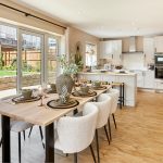 Modern kitchen and dining area with wooden flooring.