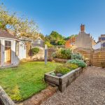 Charming garden with wooden summer house and raised beds.
