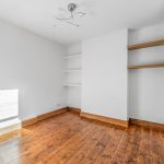 Empty room with wooden floor and white walls.