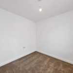 Empty white room with lightbulb and carpet.