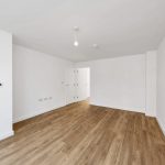 Empty room with wooden floor and white walls.