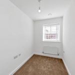 Small empty room, white walls, carpeted floor.
