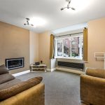 Cosy living room with fireplace and window view.