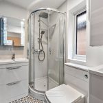 Modern bathroom with glass shower and vanity unit.
