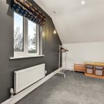 Minimalist room with window, clothes rail, and storage.