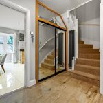 Modern hallway with stairs and dining area.​​