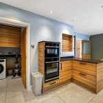 Modern kitchen with utility room and dining area.