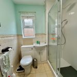 Modern bathroom with shower, toilet and sink.