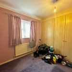 Room with clutter and closed curtains.