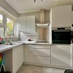 Modern kitchen interior with white cabinets and appliances.