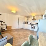 Modern kitchen with dining and exercise area.