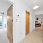 Modern hallway with doors to bedroom and dining room.