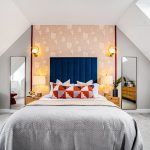 Modern bedroom with stylish decor and blue headboard.