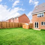 Fenced garden with new-build brick house