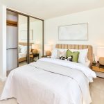 Modern bedroom with mirrored wardrobe and stylish decor.