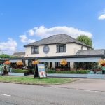 Charming countryside pub with outdoor seating and flowers.