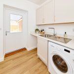 Modern utility room with washer and wooden floor