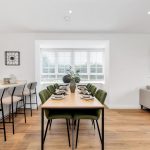 Modern open-plan kitchen and dining area with wooden floor.