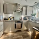 Modern kitchen with white cabinets and appliances.