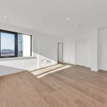Empty room with large window and wooden floor