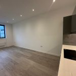 Modern empty kitchen-living room with wooden floor.
