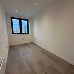 Empty room with wooden floor and large window
